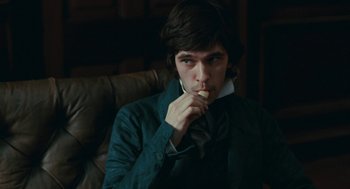 Movie still from “Bright Star” (2009), directed by Jane Campion – A man sitting in a chair with his hand to his mouth; Medium shot, High angle
