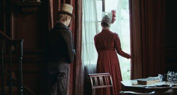 Movie still from “Bright Star” (2009), directed by Jane Campion – A man and a woman dressed in period clothing looking out a window; Medium shot, Over the shoulder angle