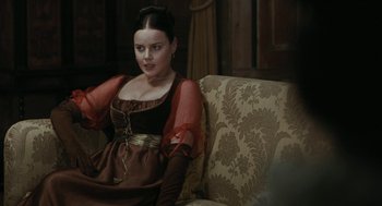Movie still from “Bright Star” (2009), directed by Jane Campion – A woman sitting on top of a couch in a room; Medium shot, Over the shoulder angle