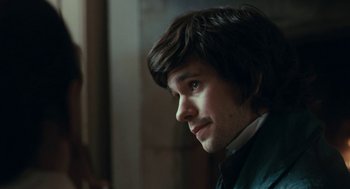 Movie still from “Bright Star” (2009), directed by Jane Campion – A young man with long brown hair looking to his left; Close Up shot, Over the shoulder angle