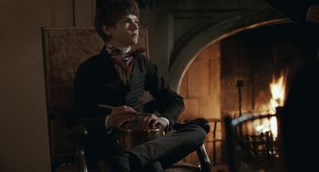 Movie still from “Bright Star” (2009), directed by Jane Campion – A man sitting in a chair with a pan in front of a fireplace; Medium shot, Low angle
