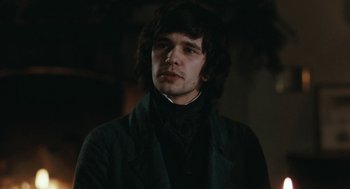 Movie still from “Bright Star” (2009), directed by Jane Campion – A man with long black hair wearing a black suit; Close Up shot, Over the shoulder angle