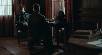 Movie still from “Bright Star” (2009), directed by Jane Campion – Two people sitting at a table in front of a laptop; Medium shot, Over the shoulder angle