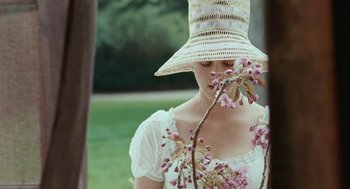 Movie still from “Bright Star” (2009), directed by Jane Campion – A woman wearing a straw hat sniffs a flower; Close Up shot, Over the shoulder angle