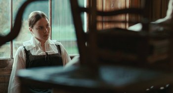 Movie still from “Bright Star” (2009), directed by Jane Campion – A woman sitting in front of a wooden chair; Medium shot, Over the shoulder angle