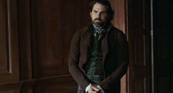Movie still from “Bright Star” (2009), directed by Jane Campion – A man standing in front of a wooden wall; Medium shot, Over the shoulder angle