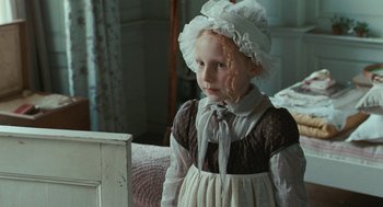 Movie still from “Bright Star” (2009), directed by Jane Campion – A little girl wearing a white dress and a white hat; Medium shot, High angle