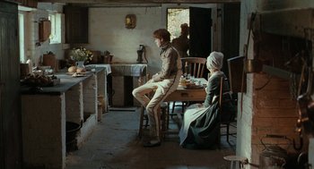 Movie still from “Bright Star” (2009), directed by Jane Campion – A man and a woman sitting at a table in a kitchen; Wide shot, Over the shoulder angle
