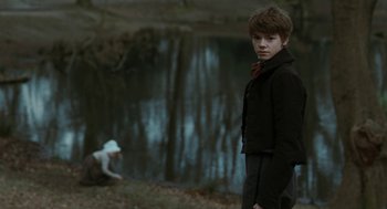 Movie still from “Bright Star” (2009), directed by Jane Campion – A young man standing next to a body of water; Medium shot, Over the shoulder angle