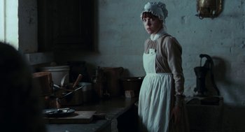 Movie still from “Bright Star” (2009), directed by Jane Campion – A woman standing in front of a kitchen counter; Medium shot, Low angle