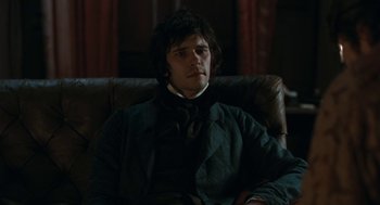 Movie still from “Bright Star” (2009), directed by Jane Campion – A man sitting in a leather chair in a dark room; Medium shot, Over the shoulder angle