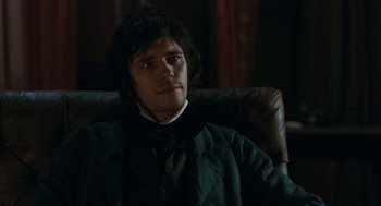 Movie still from “Bright Star” (2009), directed by Jane Campion – A man sitting in a chair in a dark room; Close Up shot, Over the shoulder angle