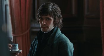 Movie still from “Bright Star” (2009), directed by Jane Campion – A man with long dark hair wearing a suit; Close Up shot, Over the shoulder angle