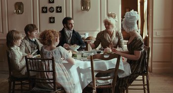 Movie still from “Bright Star” (2009), directed by Jane Campion – A group of people sitting around a table eating food; Medium shot, High angle