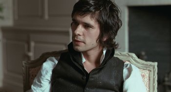 Movie still from “Bright Star” (2009), directed by Jane Campion – A man with long black hair sitting in a chair; Close Up shot, Over the shoulder angle