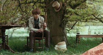 Movie still from “Bright Star” (2009), directed by Jane Campion – A boy sitting on a chair next to a tree; Medium shot, High angle