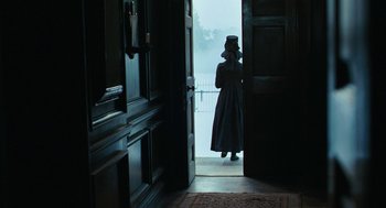 Movie still from “Bright Star” (2009), directed by Jane Campion – A woman in a long dress standing in a doorway; Wide shot, Over the shoulder angle