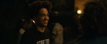 A young man smiling for the camera in the dark