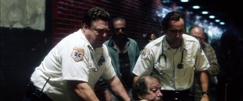 Movie still from “Bringing Out the Dead” (1999), directed by Martin Scorsese – A group of men standing next to each other in a room; Medium shot, Low angle