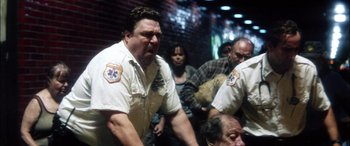 Movie still from “Bringing Out the Dead” (1999), directed by Martin Scorsese – A group of people sitting in a room; Medium shot, Low angle