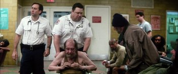 Movie still from “Bringing Out the Dead” (1999), directed by Martin Scorsese – A group of men standing next to each other in a room; Wide shot, Over the shoulder angle