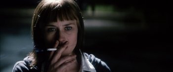 Movie still from “Bringing Out the Dead” (1999), directed by Martin Scorsese – A woman smoking a cigarette in a dark room; Close Up shot, Low angle