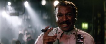 Movie still from “Bringing Out the Dead” (1999), directed by Martin Scorsese – An older man holding a cigar and smiling for the camera; Close Up shot, Low angle