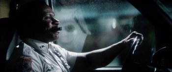 Movie still from “Bringing Out the Dead” (1999), directed by Martin Scorsese – A man driving a car in the rain; Close Up shot, Low angle