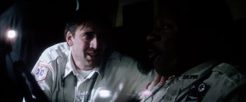 Movie still from “Bringing Out the Dead” (1999), directed by Martin Scorsese – A man and a woman are talking to each other in a dark room; Close Up shot, Over the shoulder angle