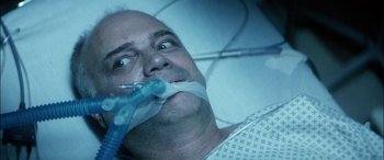 Movie still from “Bringing Out the Dead” (1999), directed by Martin Scorsese – A man in a hospital bed holding a toothbrush in his mouth; Close Up shot, Overhead angle
