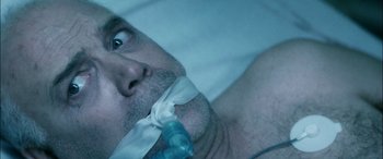 Movie still from “Bringing Out the Dead” (1999), directed by Martin Scorsese – A man's face while he lies in bed; Extreme Close Up shot, Overhead angle