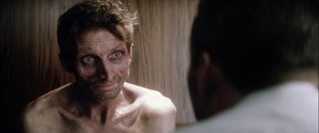 Movie still from “Bringing Out the Dead” (1999), directed by Martin Scorsese – A shirtless man looking into a mirror; Close Up shot, Over the shoulder angle