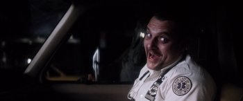 Movie still from “Bringing Out the Dead” (1999), directed by Martin Scorsese – A man in a white shirt is in the back of a car; Close Up shot, Low angle