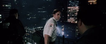 Movie still from “Bringing Out the Dead” (1999), directed by Martin Scorsese – A man standing on top of a building at night; Medium shot, Low angle