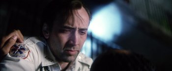Movie still from “Bringing Out the Dead” (1999), directed by Martin Scorsese – A man looking down at his face in a dark room; Close Up shot, Over the shoulder angle