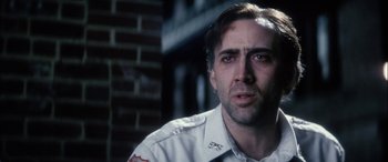 Movie still from “Bringing Out the Dead” (1999), directed by Martin Scorsese – A man with a bandage on his head and face looking at the camera; Close Up shot, Over the shoulder angle