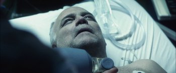 Movie still from “Bringing Out the Dead” (1999), directed by Martin Scorsese – An older man is holding something in his mouth; Close Up shot, Overhead angle