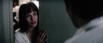 Movie still from “Bringing Out the Dead” (1999), directed by Martin Scorsese – A woman looking into a mirror while standing next to a wall; Close Up shot, Over the shoulder angle