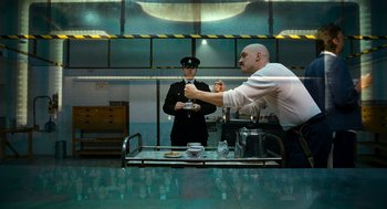 Movie still from “Bronson” (2008), directed by Nicolas Winding Refn – A man in a white dress shirt and a man in a black tie; Medium shot, Over the shoulder angle