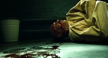 Movie still from “Bronson” (2008), directed by Nicolas Winding Refn – A man laying on the ground covered in blood; Close Up shot, Overhead angle