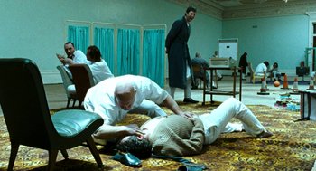Movie still from “Bronson” (2008), directed by Nicolas Winding Refn – A man and a woman laying on the floor; Wide shot, High angle