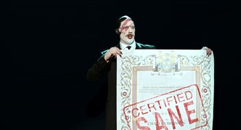 Movie still from “Bronson” (2008), directed by Nicolas Winding Refn – A man in a tuxedo holding a certificate; Medium shot, High angle