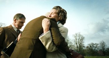 Movie still from “Bronson” (2008), directed by Nicolas Winding Refn – A woman is hugging a man in a brown coat; Medium shot, Low angle