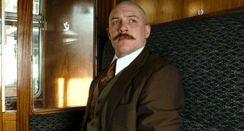 Movie still from “Bronson” (2008), directed by Nicolas Winding Refn – A man in a suit and tie with a mustache; Close Up shot, Low angle