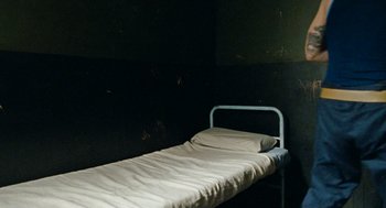 Movie still from “Bronson” (2008), directed by Nicolas Winding Refn – An empty hospital bed in a dark room; Wide shot, High angle