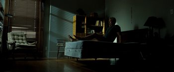 Movie still from “Brooklyn's Finest” (2009), directed by Antoine Fuqua – A man sitting on top of a bed in a room; Wide shot, Low angle