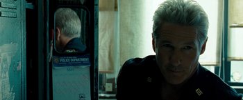 Movie still from “Brooklyn's Finest” (2009), directed by Antoine Fuqua – A man sitting in front of a mirror in a room; Close Up shot, Over the shoulder angle