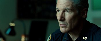 Movie still from “Brooklyn's Finest” (2009), directed by Antoine Fuqua – A man in a police uniform looking into the distance; Close Up shot, Over the shoulder angle
