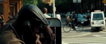 Movie still from “Brooklyn's Finest” (2009), directed by Antoine Fuqua – A man sitting on a bench smoking a cigarette on the side of the street; Close Up shot, Over the shoulder angle