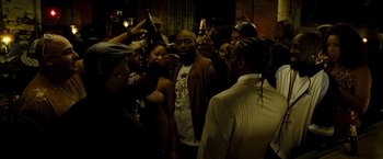 Movie still from “Brooklyn's Finest” (2009), directed by Antoine Fuqua – A group of people standing around each other holding wine glasses; Medium shot, High angle